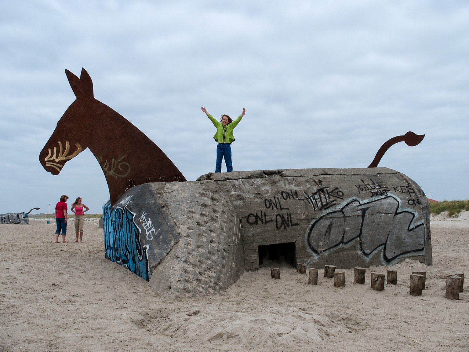Beach bunker with a giant horse sculpture and a person standing above it