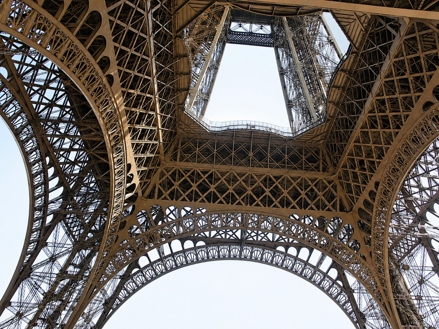 Looking upward through the iron structure of the Eiffel Tower