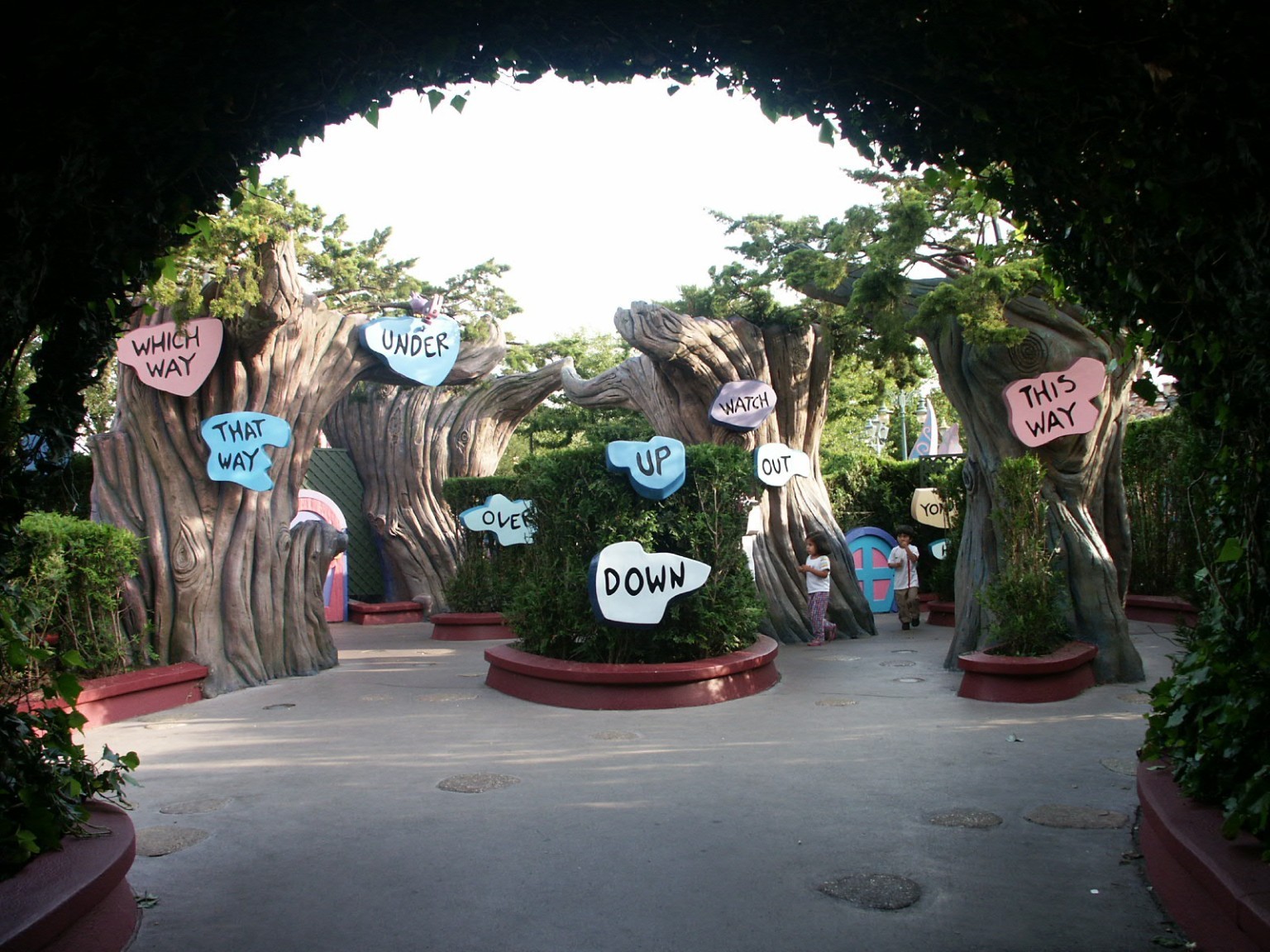 Whimsical directional signs among sculpted trees